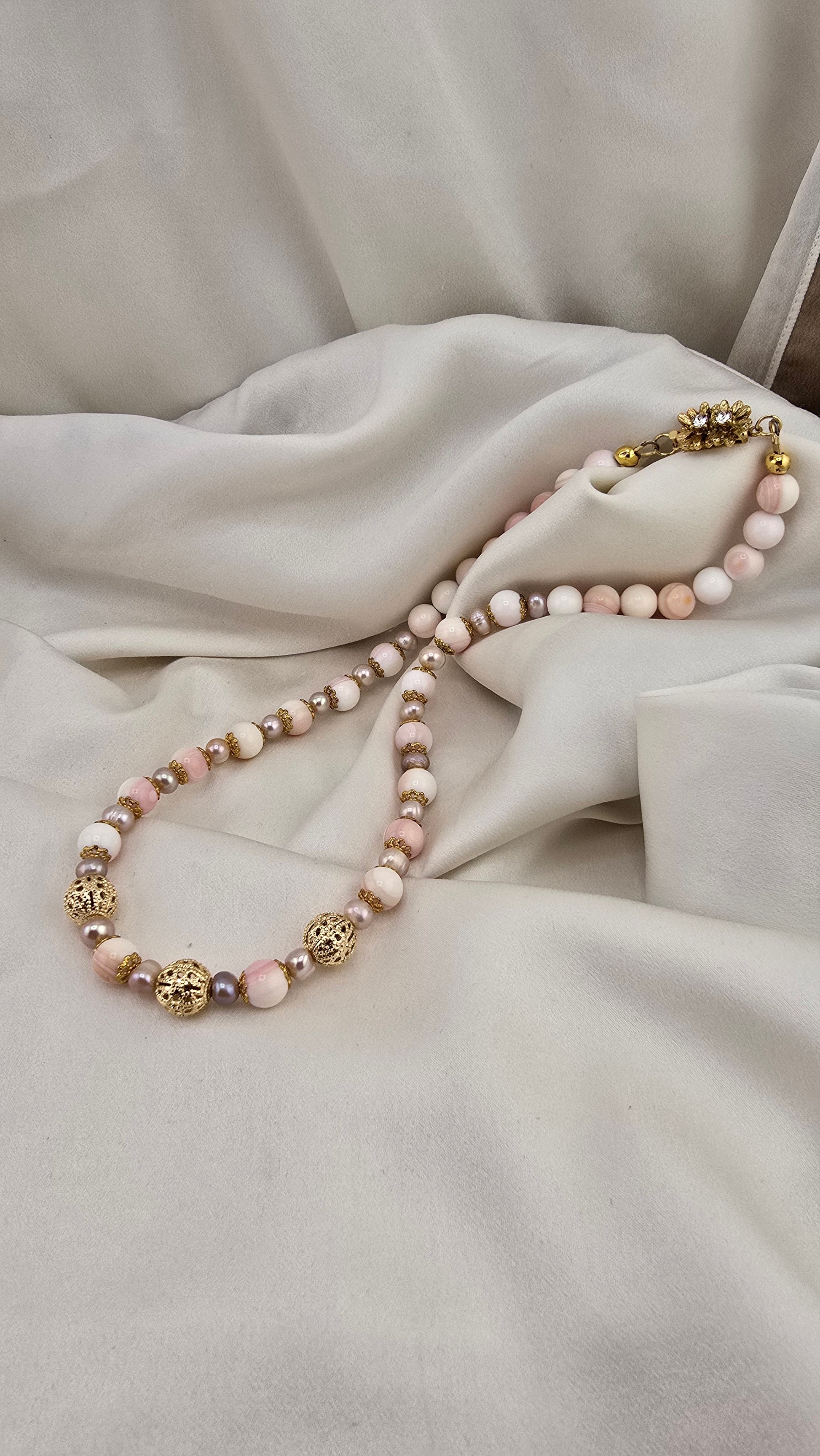 Cultured pearl and conch pearl necklace in its case