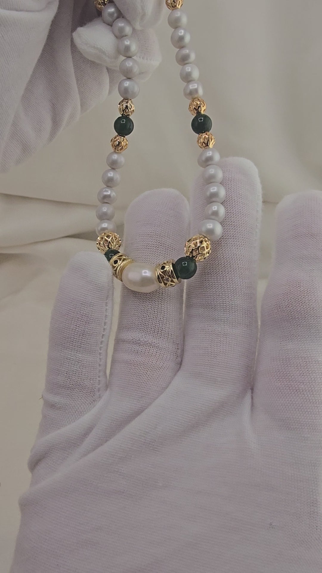 Cultured pearl and emerald necklace in its prestige box