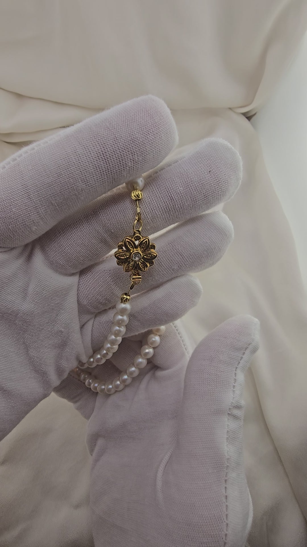 Necklace made of round, white cultured pearls in its case