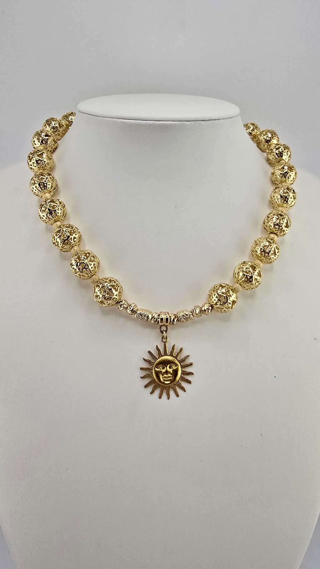 Collier doré et son pendentif soleil