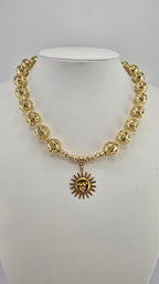 Collier doré et son pendentif soleil