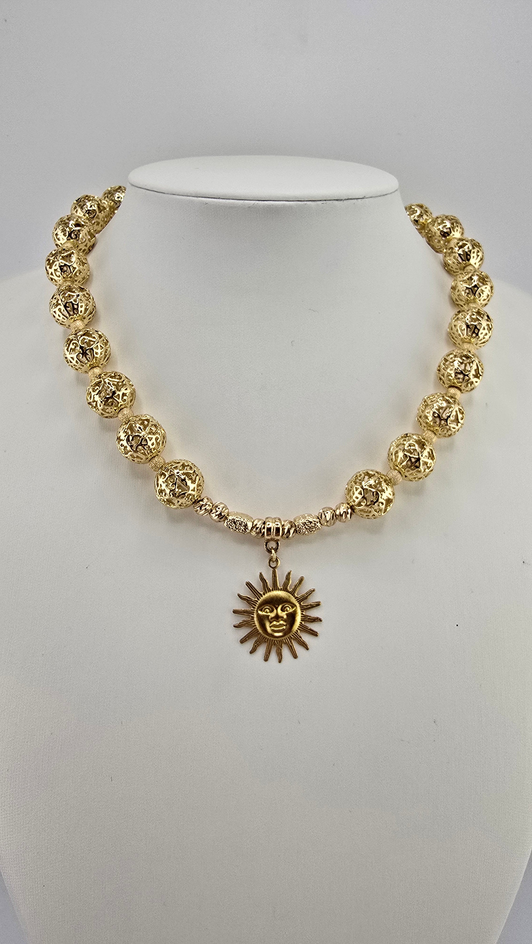 Collier doré et son pendentif soleil