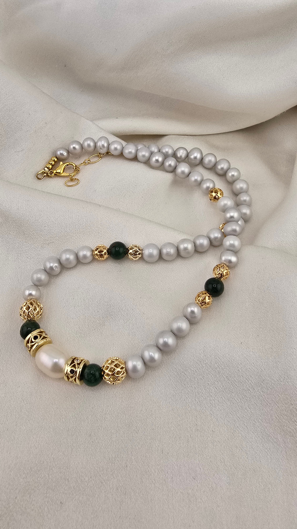 Cultured pearl and emerald necklace in its prestige box