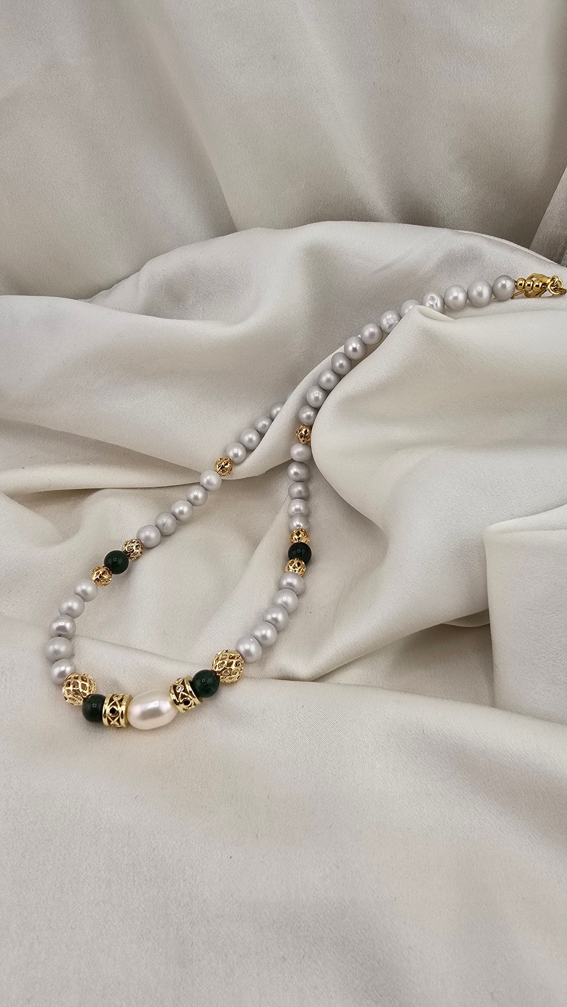 Cultured pearl and emerald necklace in its prestige box